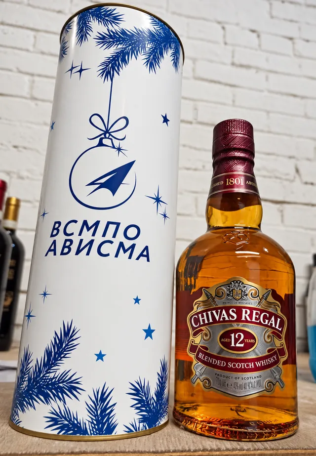 Брендированный белый тубус с еловыми ветками и бутылка виски